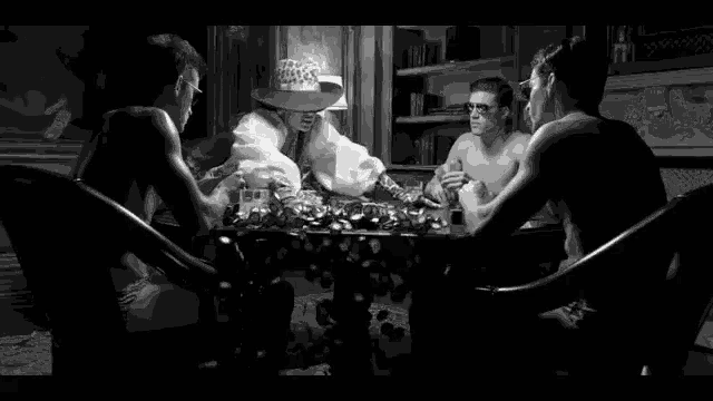 a group of people are sitting around a table playing a game of cards .