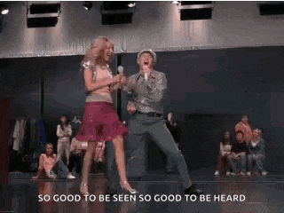 a man and a woman are dancing on a stage in front of a crowd .