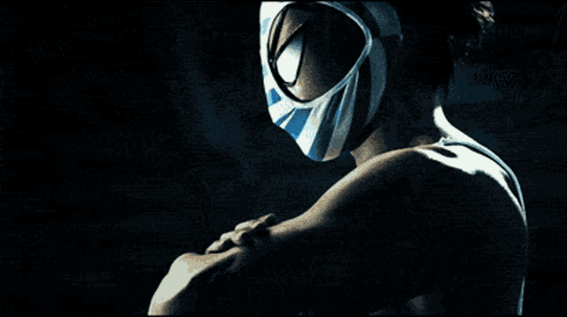 a man with a mask on his face is standing in a dark room