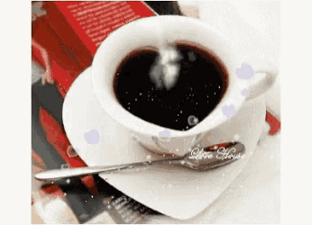 a cup of coffee with a spoon on a saucer with the word love house on the bottom