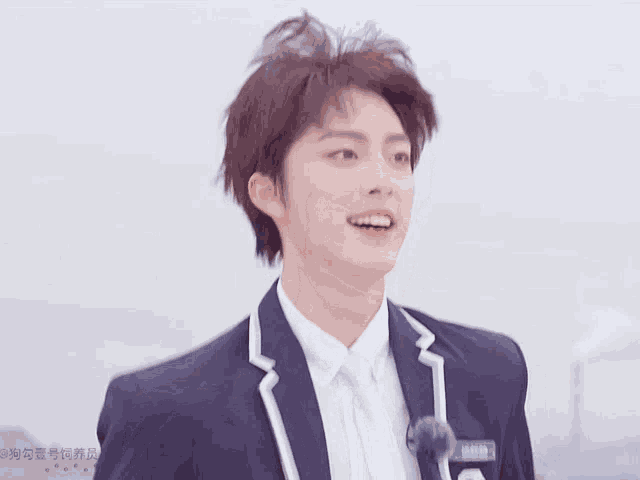 a young man in a suit is smiling with chinese writing on the bottom