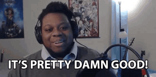a man wearing headphones is sitting in front of a microphone and says `` it 's pretty damn good '' .