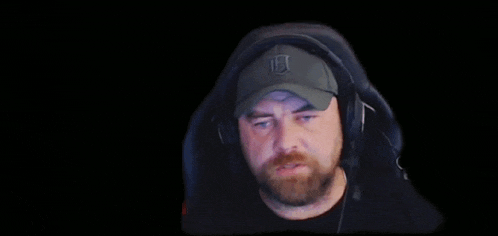 a man wearing headphones and a hat is making a funny face on a black background .