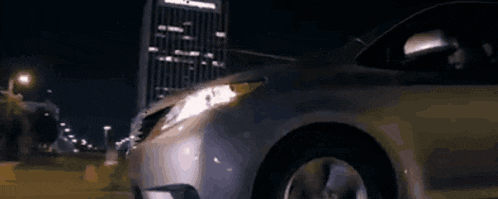 a silver van is parked in front of a house at night