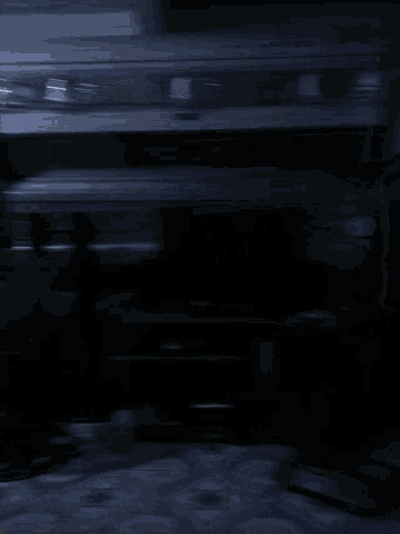 a fan is hanging on a wall in a dark room with a blue and white tile floor
