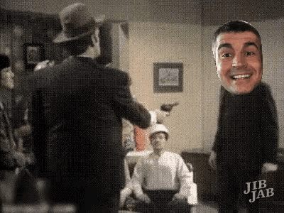 a group of men are standing in a room and one of them has a face on his chest .