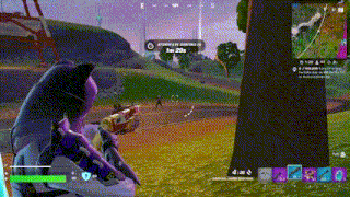a person is playing a video game in a field with a tree in the foreground .