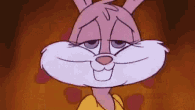 a close up of a pink and white cartoon rabbit wearing a yellow shirt .