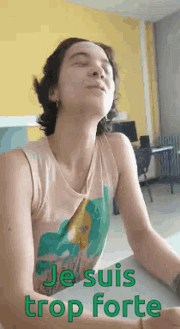 a woman in a tank top is sitting at a table with her eyes closed and the words je suis trop forte on the bottom .