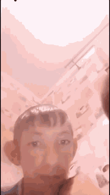 a young boy is taking a selfie in a bedroom with a pink wall .