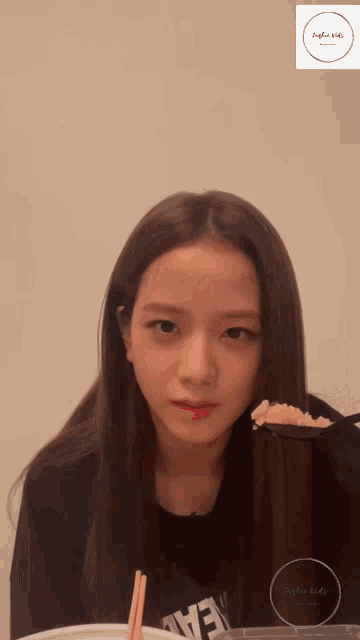 a woman with long hair wearing a black shirt that says " love "