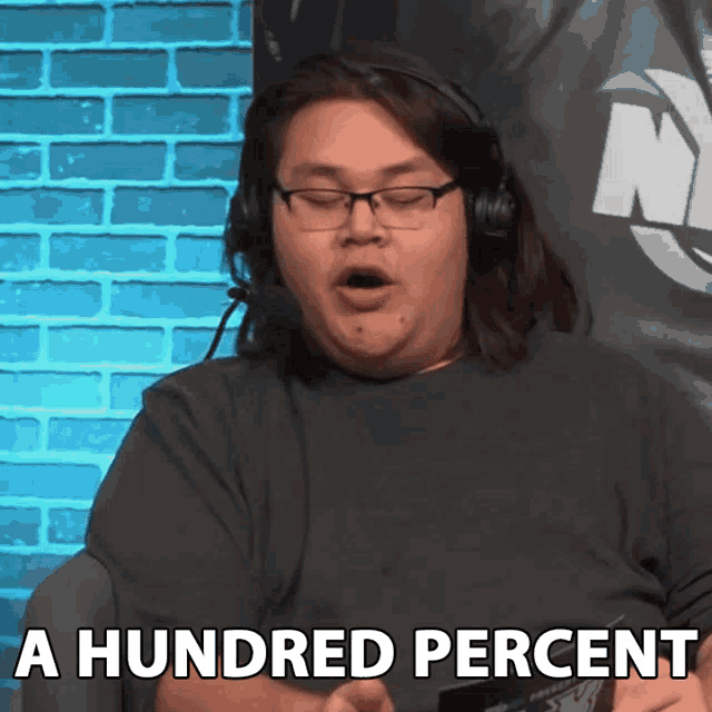 a man wearing headphones and glasses says " a hundred percent "