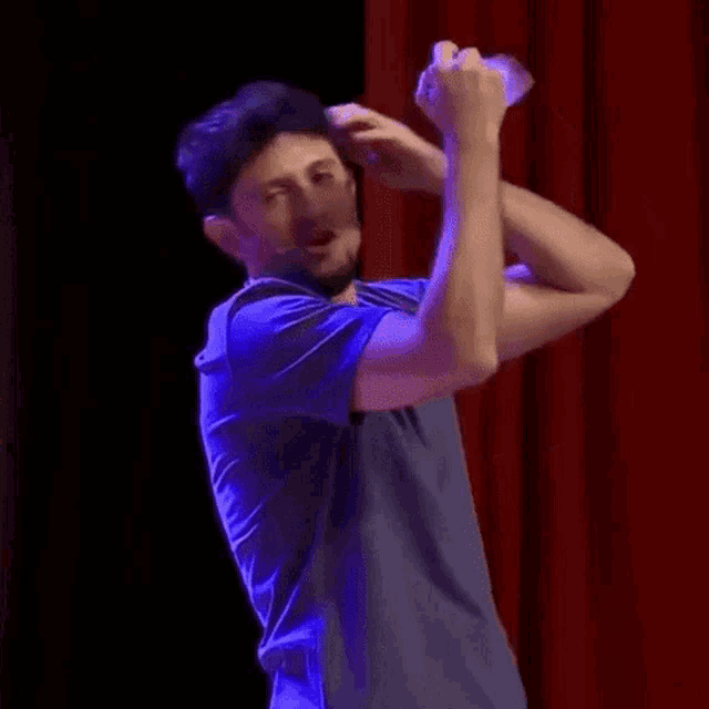 a man is holding a bottle of water over his head