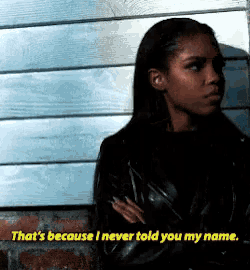 a woman leaning against a wall with the words " that 's because i never told you my name "