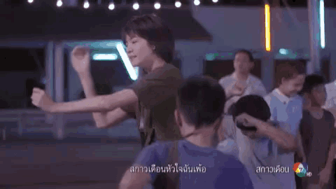 a group of people are dancing in a room with a sign that says ' a ' on it .