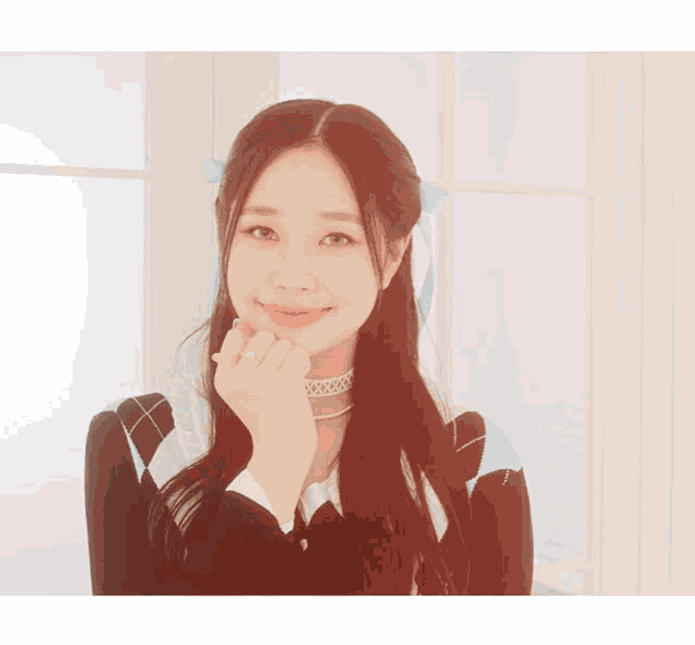a woman wearing a choker and a black and white sweater winks at the camera