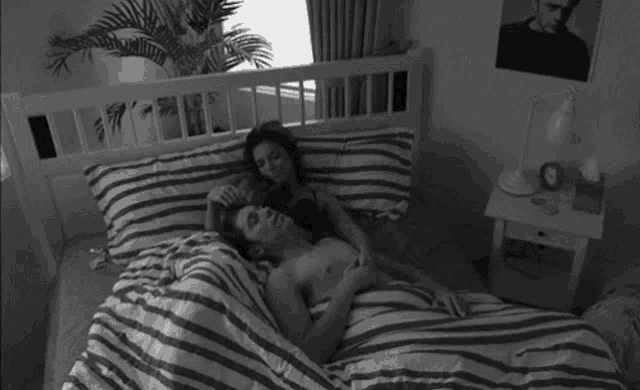 a man and a woman are laying on a bed .