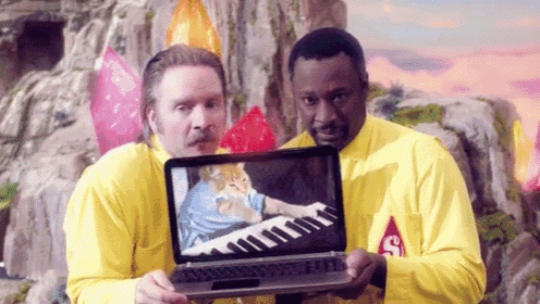 two men in yellow shirts are holding a laptop with a picture of jesus on the screen