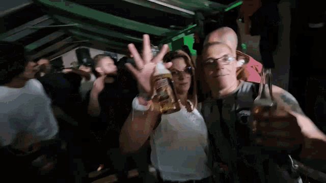 a woman holds a bottle of beer and a man holds a glass