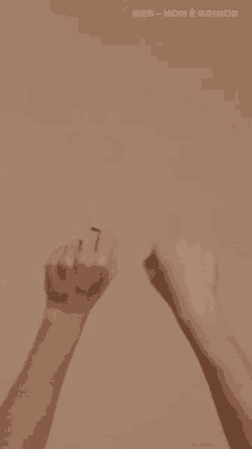 a woman with purple nails is giving the middle finger to another woman .