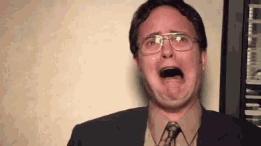 a man wearing glasses is crying with his mouth open