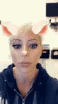 a woman wearing a bunny ear filter on her face .