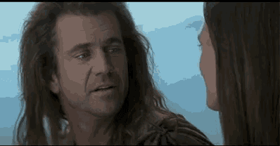 a man and a woman are looking at each other in a movie .