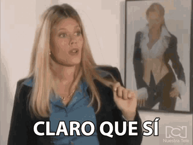 a woman says claro que si in front of a picture of herself