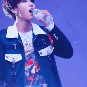 a man drinking from a bottle with a t-shirt that says sin on it