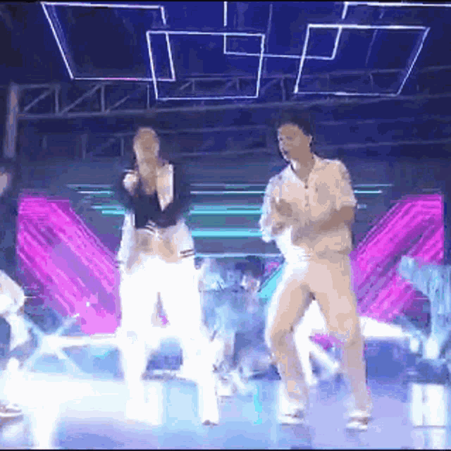 a man and a woman are dancing on a stage