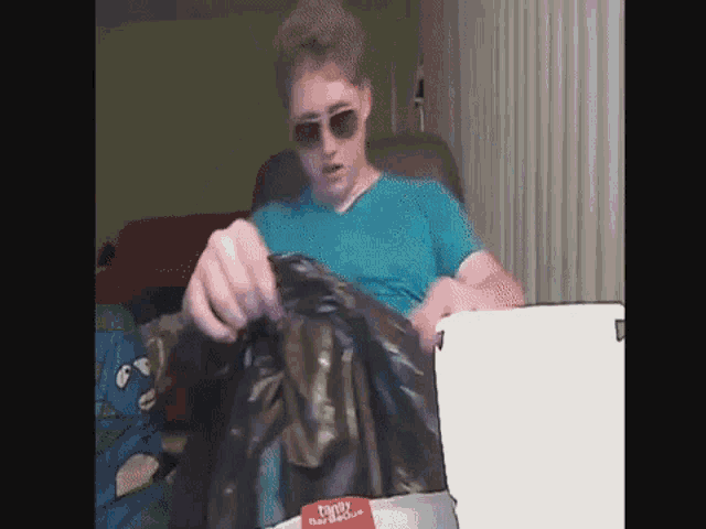 a man wearing sunglasses and a blue shirt is holding a trash bag that says family trash rescue on it