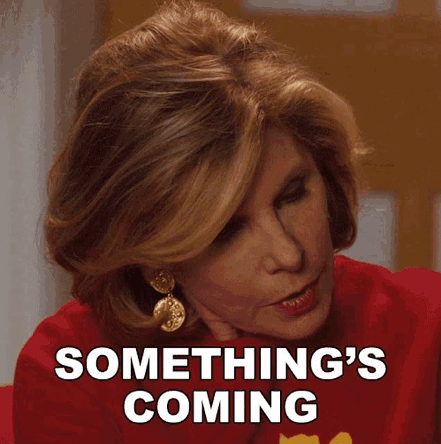 a woman in a red shirt with something 's coming written on it