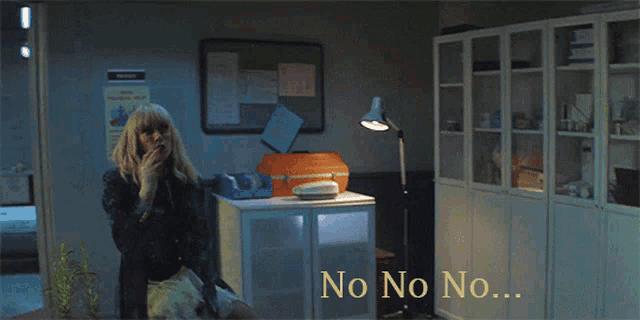 a woman in a dark room with the words no no no on the bottom right