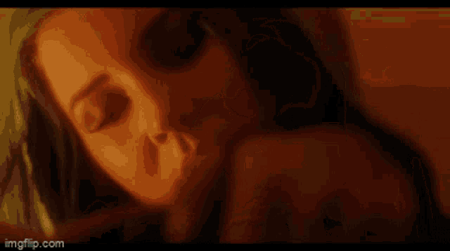 a close up of a woman 's face with a person 's hand on her neck .