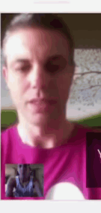 a man in a pink shirt is having a video call with another man