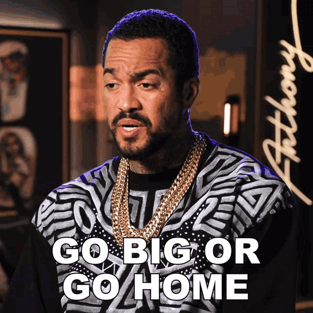 a man with a beard is wearing a black and white shirt that says go big or go home