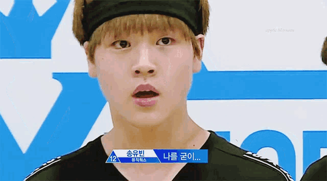 a young man wearing a headband with the number 12 written on it