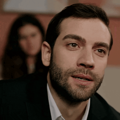 a man with a beard is looking at the camera