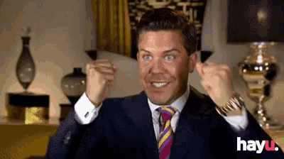 a man in a suit and tie is making a fist