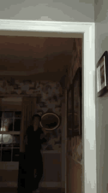 a reflection of a person in a mirror is visible in a hallway