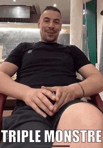 a man sitting in a chair with his hands on his stomach and the caption triple monstre above him