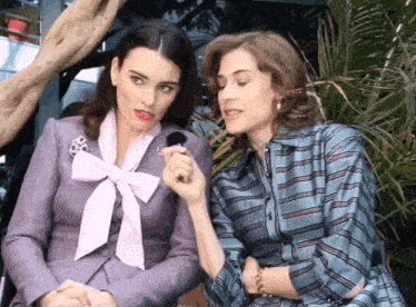 two women are sitting next to each other and one has a microphone in her hand