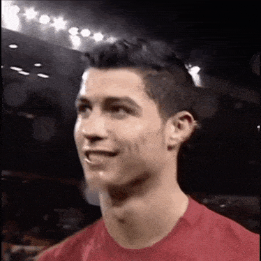 a close up of a man wearing a red shirt making a funny face .