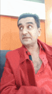 a man wearing a red shirt and a red jacket looks at the camera