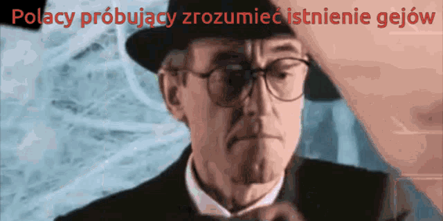 a man wearing glasses and a hat with the words polacy probujacy zrozumiec istnienie gejow written above him