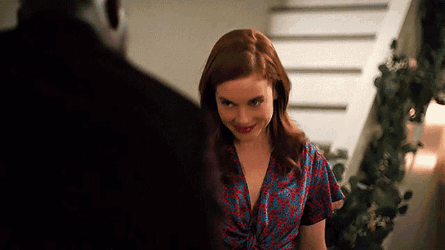 a woman in a red and blue dress is smiling at a man