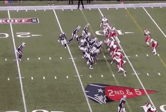 a group of football players are playing a game on a field . one of the players has the number 50 on his jersey .