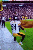 a football player wearing a number 84 jersey is kneeling on the field .