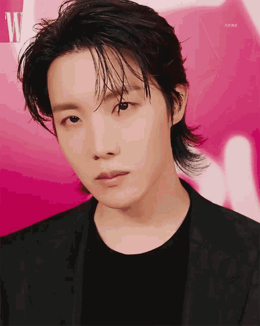 a close up of a person 's face with a pink background and the letter w on it