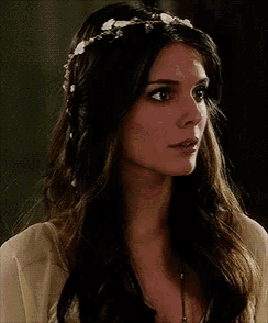 a woman wearing a crown of flowers in her hair